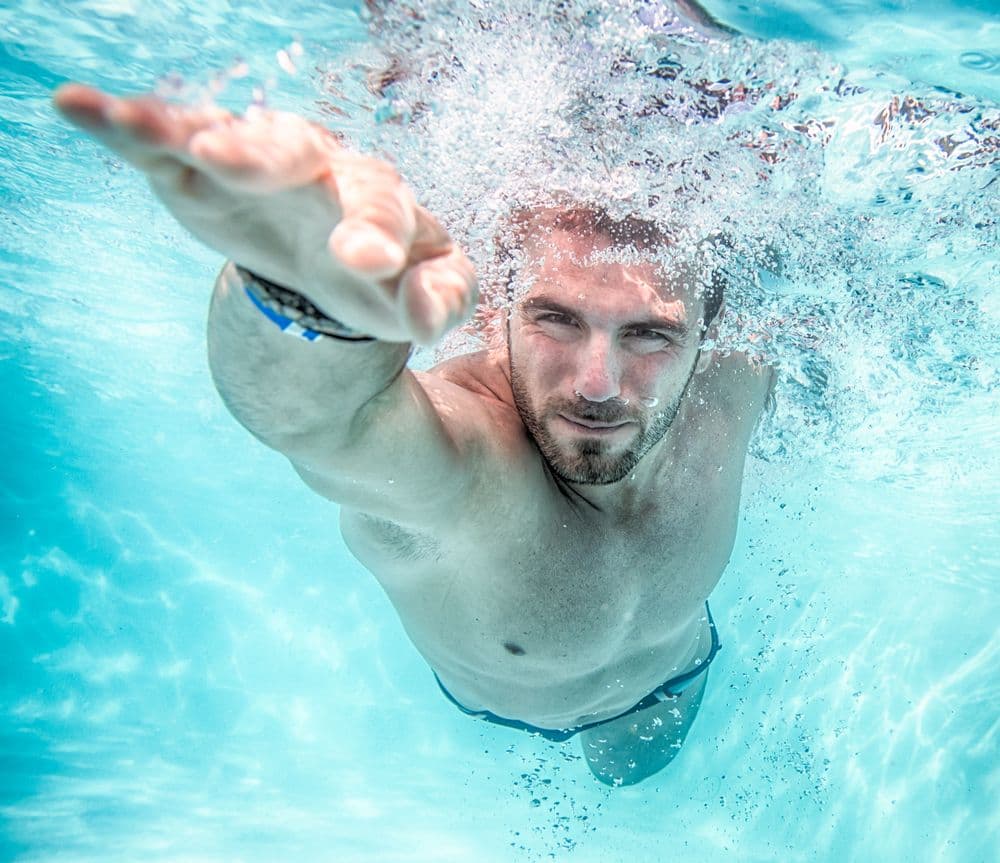 Young,man,swimming,the,front,crawl,in,a,pool,,taken